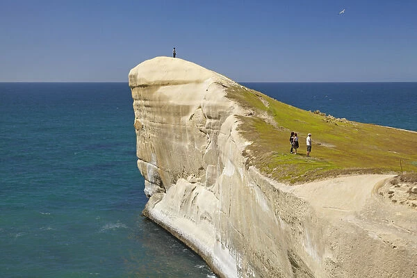 Tourists on cliff top at Tunnel Beach, Dunedin, South Island, New Zealand