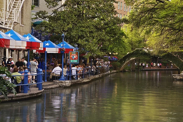 Tourists dining in outdoor cafe on the famous River Walk along the San Antonio River