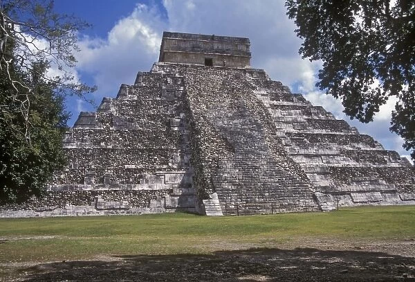 Tourists walk past an unrestored side of El Castillo, one of the Mayan structures in Chichen Itza