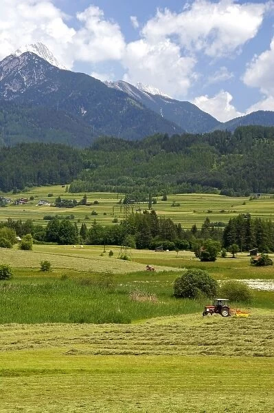 A tractor harvesting a hay field on a farm at Imst, Austria