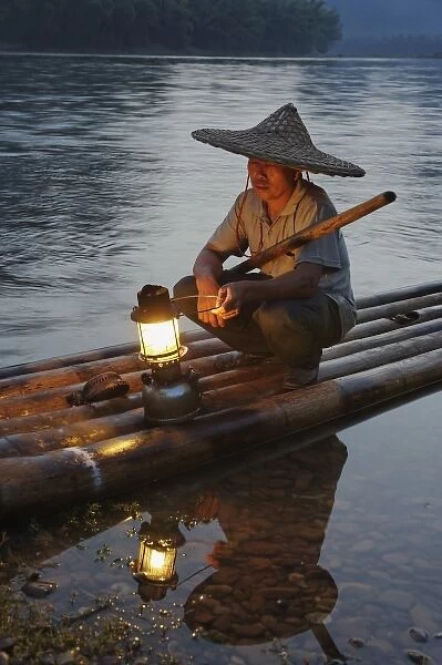Traditional fisherman with lantern at sunset, Li River, near Guilin, China