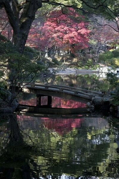 Tranquil fall setting with changing leaves reflected in pond of classical Shukkeien
