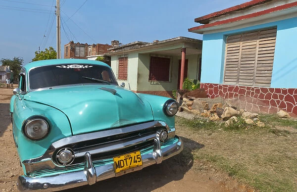 Trinidad Cuba with blue classic 1950s Chevrolet auto on cobbled streets in colorful
