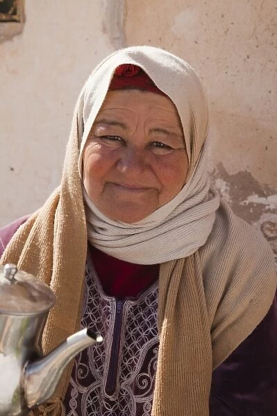 Tunisia, Ksour Area, Metameur, middle-aged Tunisian woman serving tea (MR)