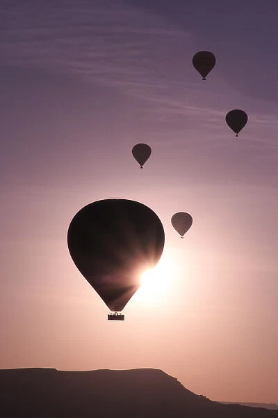 Turkey, Anatolia, Cappadocia, Goreme. Hot air balloons flying above  /  among rock formations