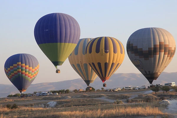 Turkey, Anatolia, Cappadocia, Goreme. Hot air balloons at lift-off, preparing to fly