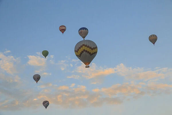 Turkey, Anatolia, Cappadocia, Goreme. Hot air balloons flying above  /  among rock formations
