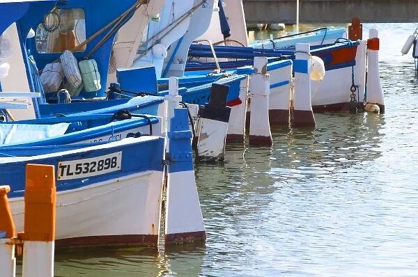 Typical Provencal fishing boats painted in bright colours white, blue, green red yellow