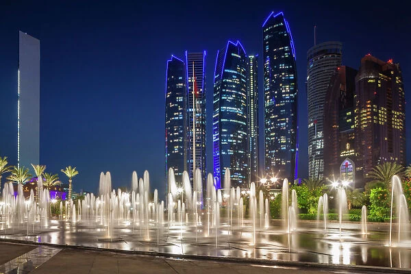 UAE, Abu Dhabi, Emirates Palace Hotel fountains and Etihad Towers, dusk