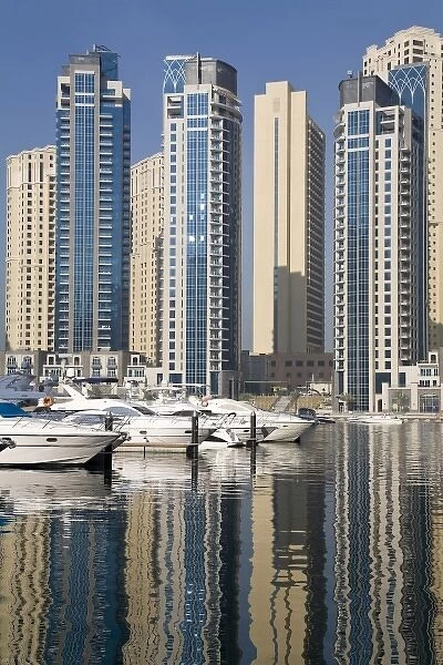 UAE, Dubai. Marina towers with boats at anchor