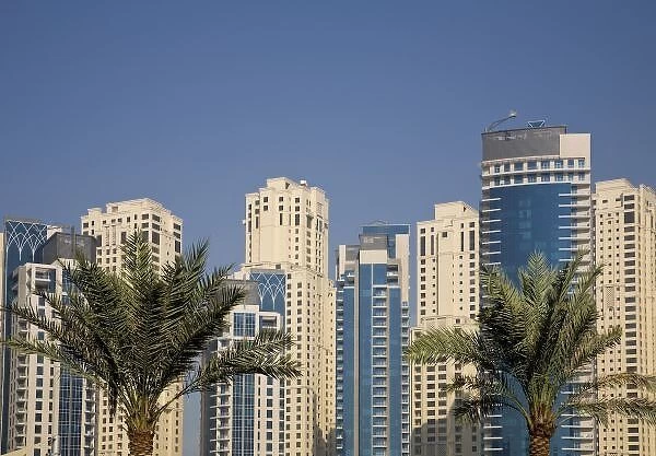 UAE, Dubai. Towers of Jumeirah Beach Residence with two palm trees in front