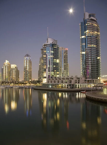 United Arab Emirates, Dubai, Marina. Towers reflect on marina at night with full moon