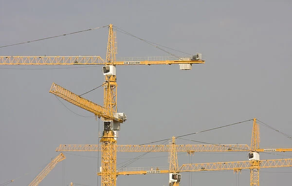 United Arab Emirates, Dubai, Marina. Yellow construction cranes against a grey sky