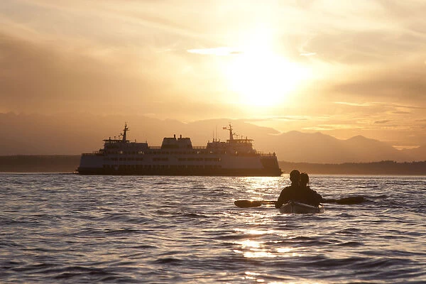 United States, Washington, Seattle. A couple paddles a two-person sea kayak in Elliott