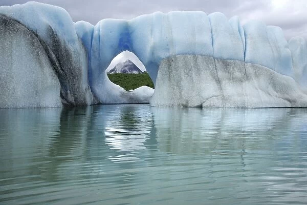 USA, Alaska, Alsek Lake. View of mountain through hole in iceberg