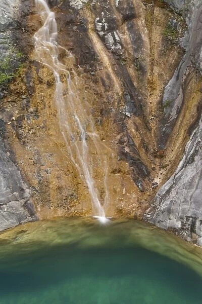 USA, Alaska, Alsek River Valley. Waterfall forms glacial pool along Alsek River