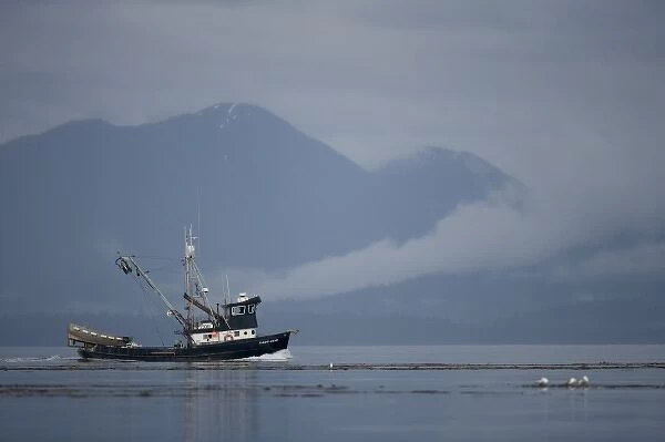 USA, Alaska, Angoon, FV Lady Jane, a salmon fishing boat, motors past fog-shrouded