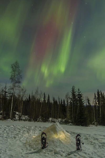 USA, Alaska, Fairbanks. A quinzee snow shelter and aurora borealis