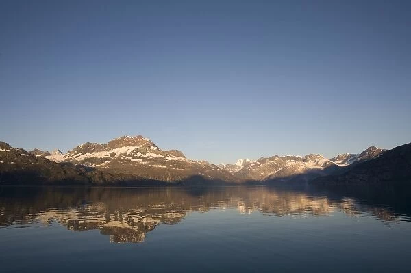 USA, Alaska, Glacier Bay National Park, Sunrise on mountains reflected in still water