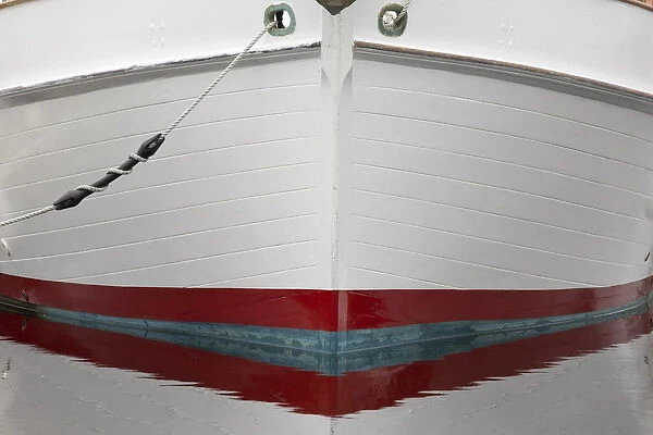 USA, Alaska, Hoonah. Bow of a boat reflects in water