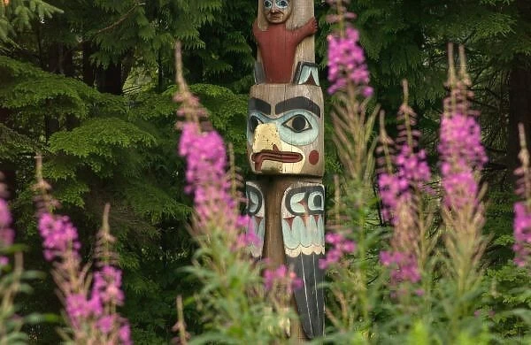 USA, Alaska, Ketchikan, Totem Bight State Park, totem pole with fireweed