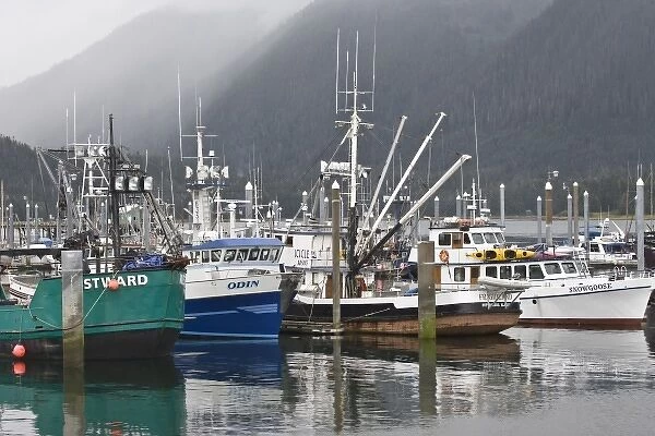 USA, Alaska, Petersburg. Fishing boats reflect in water of misty harbor