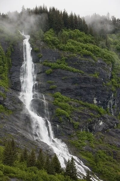 USA, Alaska, Prince William Sound, Waterfall in rainforest along Harriman Fiord