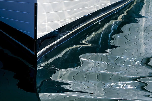 USA, Alaska. Reflection of boat bow in water