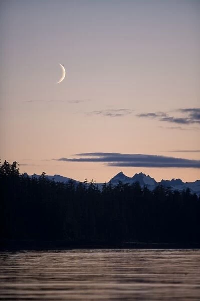 USA, Alaska, Tongass National Forest, Crescent moon sets above mountain peaks of