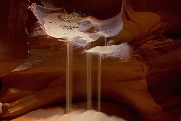 USA, Arizona, Upper Antelope Canyon. Streams of loose sand drop from rocky ledge