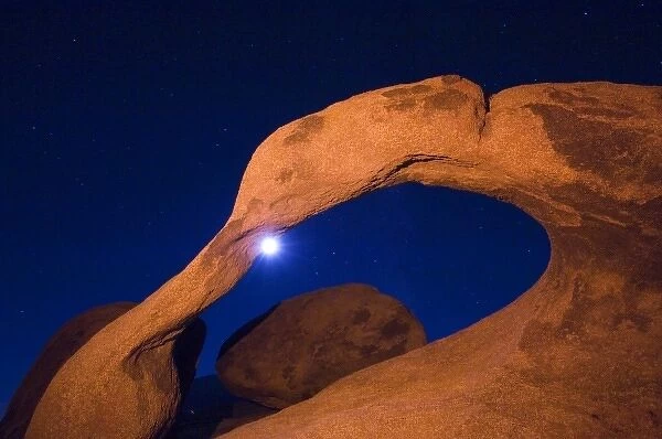 USA, California, Alabama Hills Night photo with colored flash of rock arch and moon