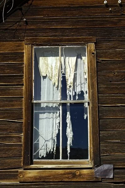 USA, California, Bodie State Historic Park, Tattered drapes hang in window of abandoned