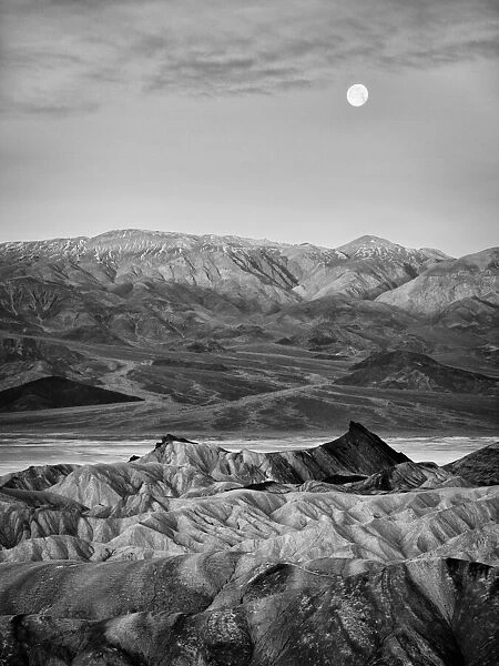 USA, California, Death Valley National Park. Moon setting at dawn over Zabriskie Point