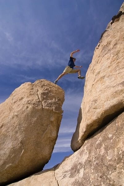 USA, California, Joshua Tree National Park. A male hiker boulder hopping. (MR)