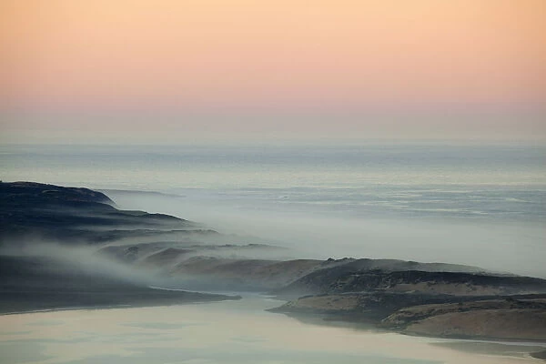 USA, California, Moro Bay. Morning fog on sand dunes and ocean