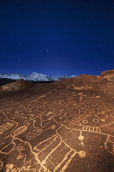 USA, California, Owens Valley. Petroglyphs covering boulder at night