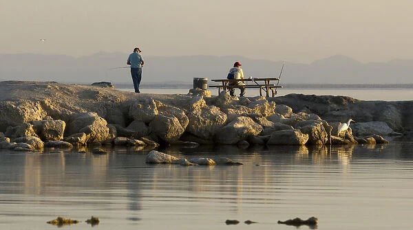 USA, California, Salton Sea. Men fishing at sunset in Salton Sea