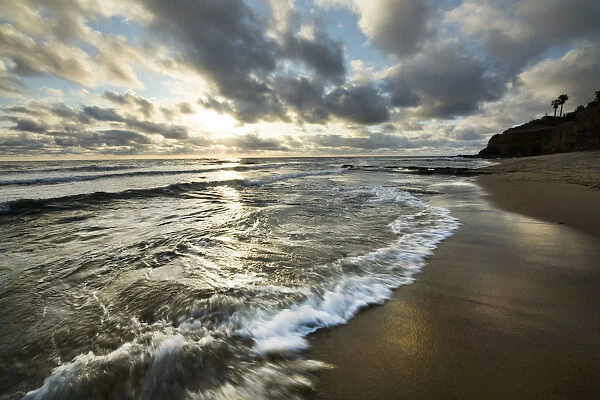 USA, California, Sunset Cliffs Park. Wave on beach at sunset