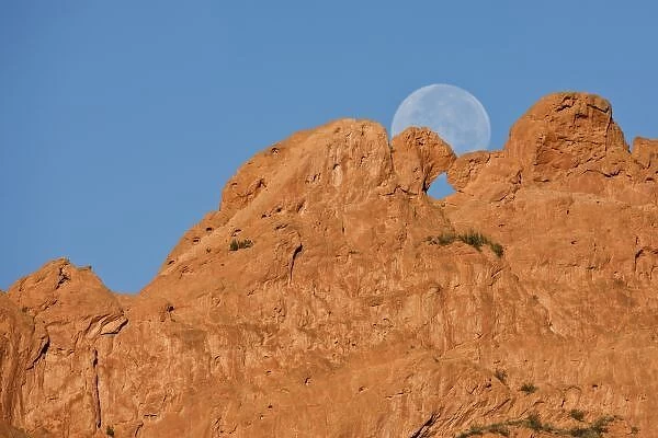 USA, Colorado, Colorado Springs, Garden of the Gods. A full moon sets behind the