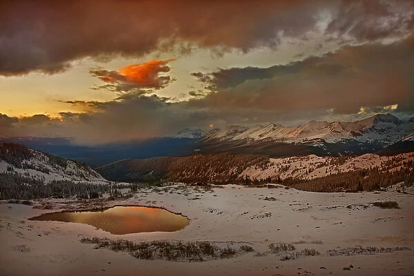 USA, Colorado, Cottonwood Pass. Sunset on alpine tarn ringed with fresh snow. Credit as