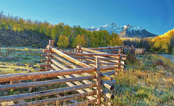 USA, Colorado, Quray. Dallas Divide, sunrise on the Mt. Snaffles with autumn colors and split rail fence