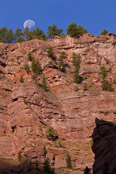 USA, Colorado, Redstone, Crystal River Canyon. Moonset on vertical red rock cliff