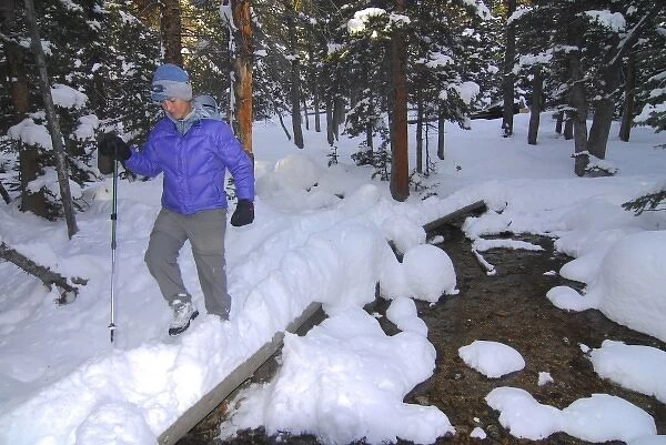 USA, Colorado, Rocky Mountain NP. A female hiker on a footpath covered by snow. (MR)