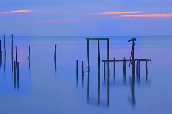 USA, Florida, Apalachicola. Remains of an old dock at sunrise