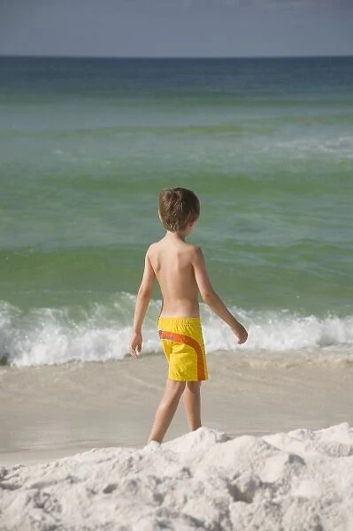 USA; Florida; Pensacola; Child walking on the beach. (MR)