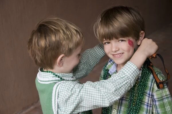 USA; Georgia; Savannah. Two young boys exchanging beads on St. Patricks Day. (MR)