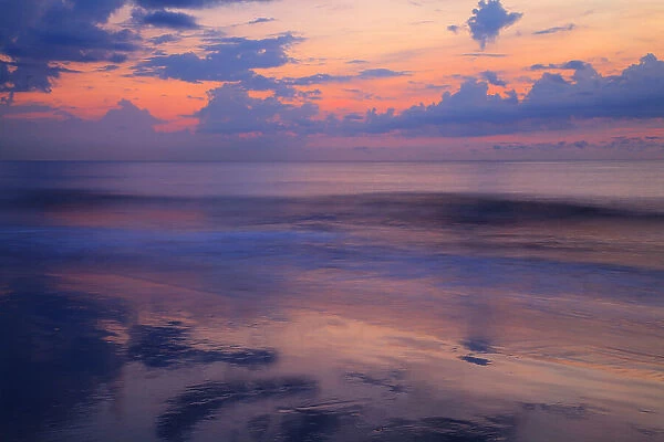 USA, Georgia, Tybee Island. Sunrise with clouds and reflections along the coast
