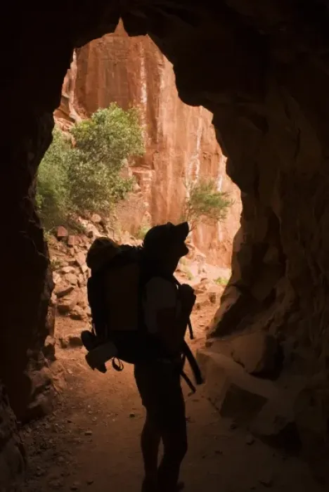 Framed Print : USA, Grand Canyon NP. A female backpacker passes through a tunnel while hiking below the North Rim