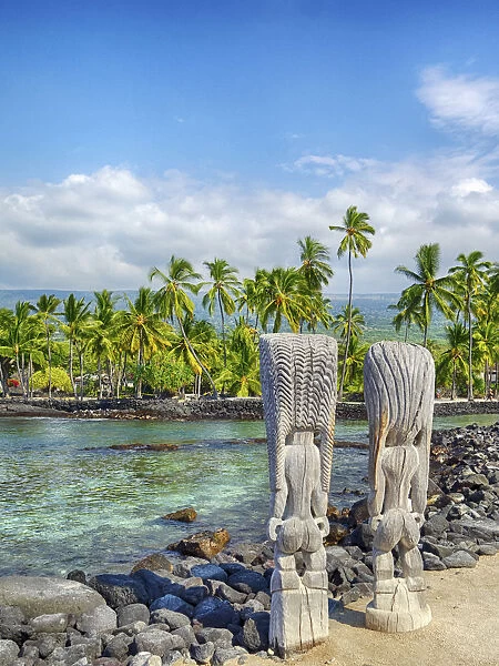 USA, Hawaii, Big Island. Palm trees and ancient tiki wooden carvings at the National
