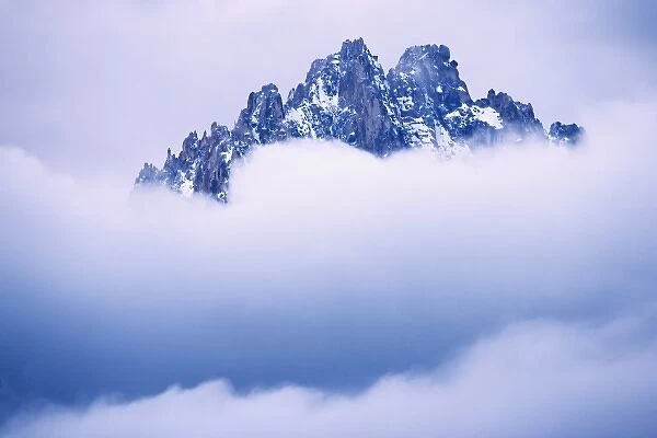 USA, Idaho, Sawtooth Range. Mountain top peaks through the heavy clouds